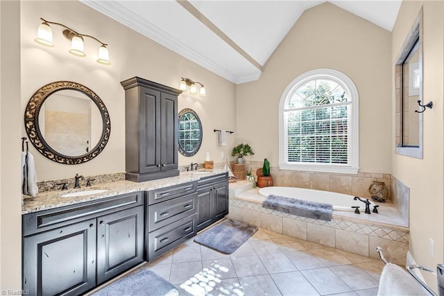 bathroom with a relaxing tiled tub, lofted ceiling, tile patterned flooring, and vanity