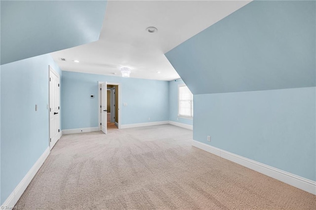 additional living space with vaulted ceiling and light colored carpet