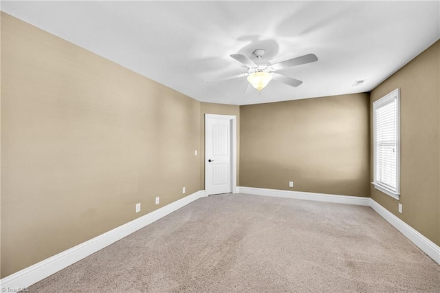 spare room with ceiling fan and carpet