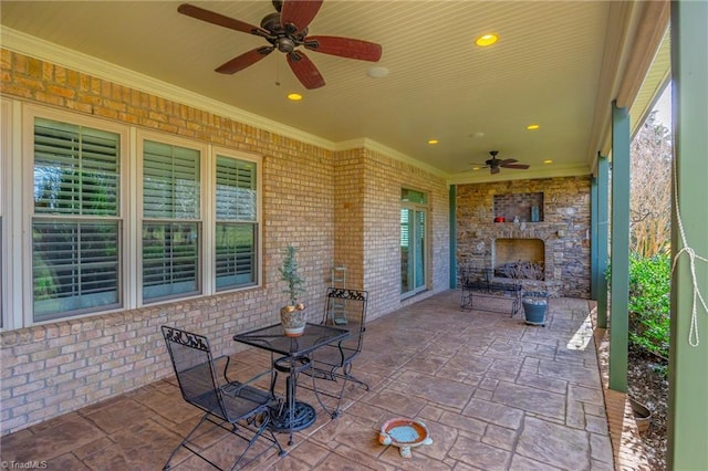 view of patio with ceiling fan and an outdoor stone fireplace