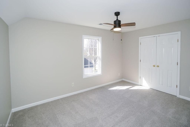 unfurnished bedroom with light colored carpet, ceiling fan, and a closet