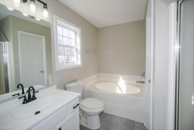 bathroom featuring vanity, a bathtub, and toilet