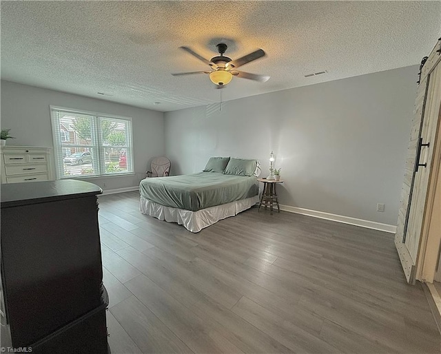 12 Cedar Knoll Ct Unit 12, Greensboro, NC 27407 - bedroom featuring a textured ceiling, wood finished floors, a ceiling fan, and a barn door