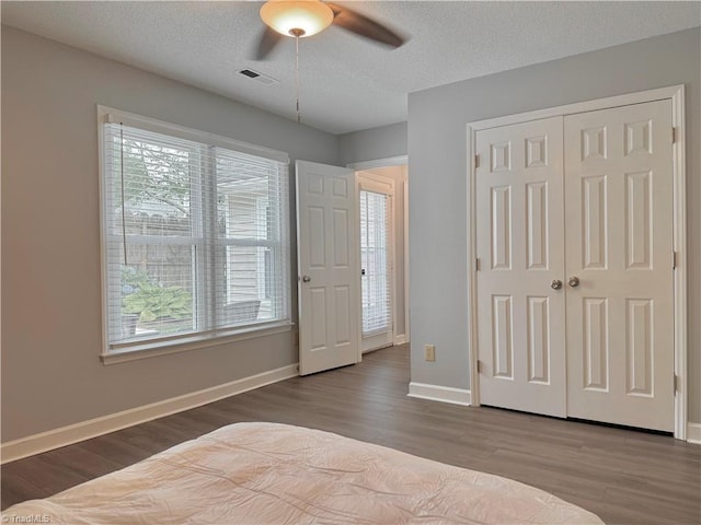 12 Cedar Knoll Ct Unit 12, Greensboro, NC 27407 - bedroom with wood finished floors, multiple windows, a closet, a ceiling fan, and a textured ceiling