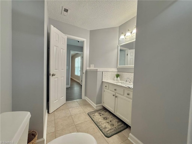 12 Cedar Knoll Ct Unit 12, Greensboro, NC 27407 - full bathroom with a freestanding tub, vanity, tile patterned flooring, tasteful backsplash, and a textured ceiling