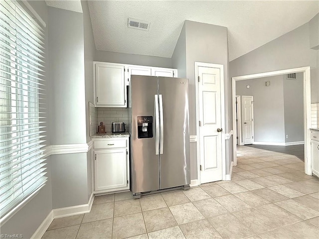 12 Cedar Knoll Ct Unit 12, Greensboro, NC 27407 - kitchen featuring stainless steel fridge, white cabinets, light tile patterned floors, decorative backsplash, and vaulted ceiling