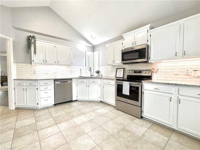 12 Cedar Knoll Ct Unit 12, Greensboro, NC 27407 - kitchen with appliances with stainless steel finishes, white cabinets, decorative backsplash, light stone countertops, and high vaulted ceiling