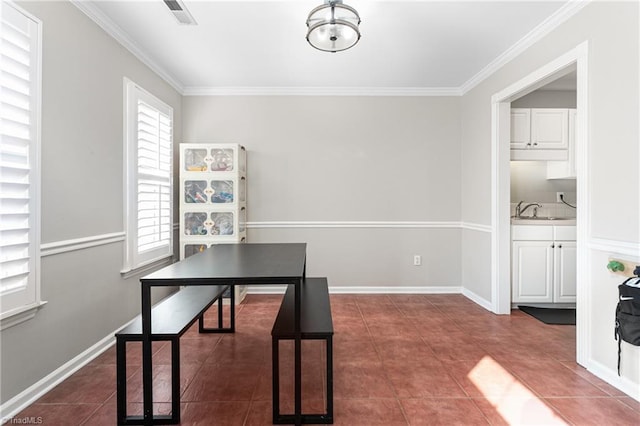 tiled dining room featuring baseboards, visible vents, ornamental molding, and a sink