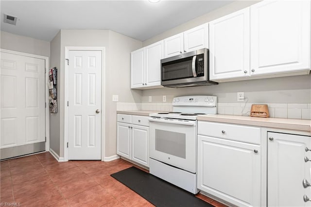 kitchen featuring visible vents, light countertops, stainless steel microwave, white cabinets, and electric stove