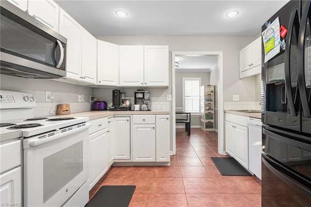 kitchen with white appliances, recessed lighting, white cabinets, and light countertops