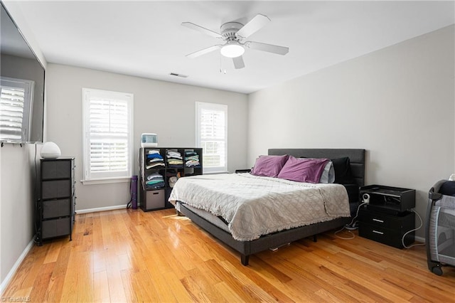 bedroom featuring a ceiling fan, baseboards, visible vents, and light wood-style floors