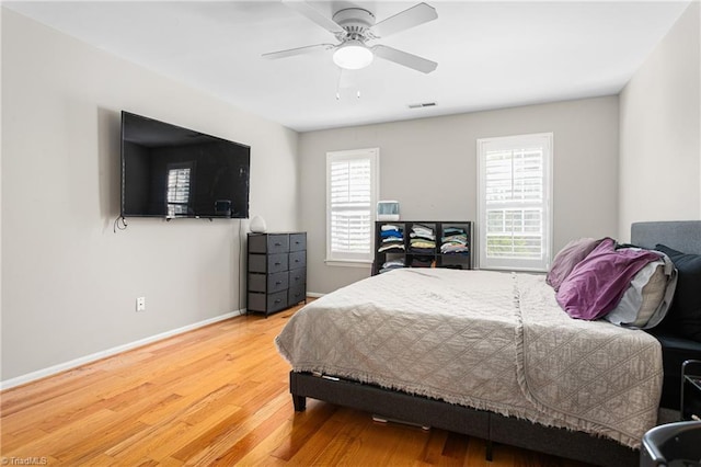 bedroom with visible vents, a ceiling fan, light wood-style floors, and baseboards