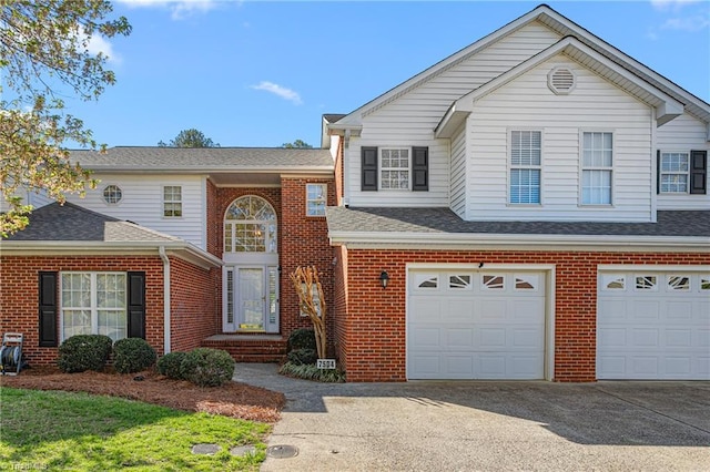 view of front of house with a garage, driveway, and brick siding