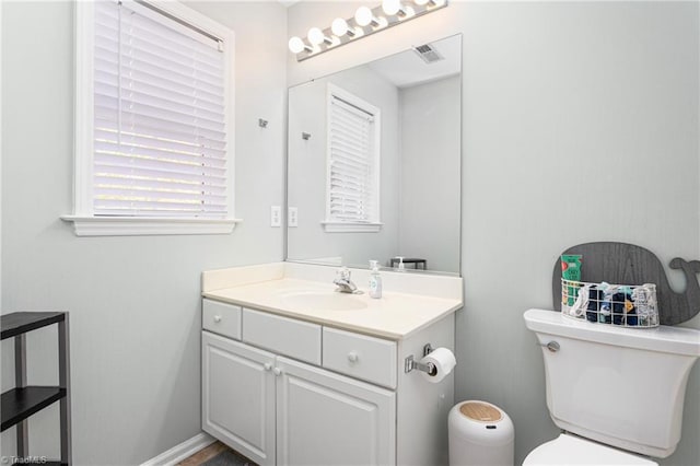 bathroom featuring vanity, toilet, and visible vents