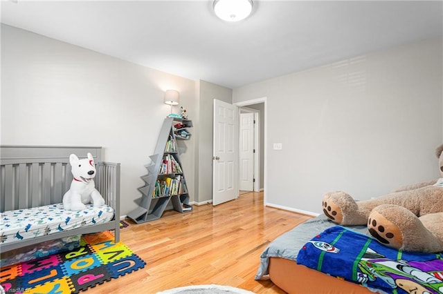 bedroom with baseboards and wood finished floors