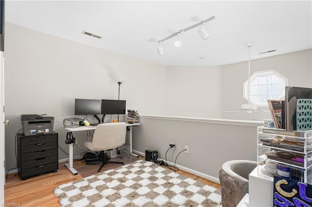 office with rail lighting, wood finished floors, and visible vents