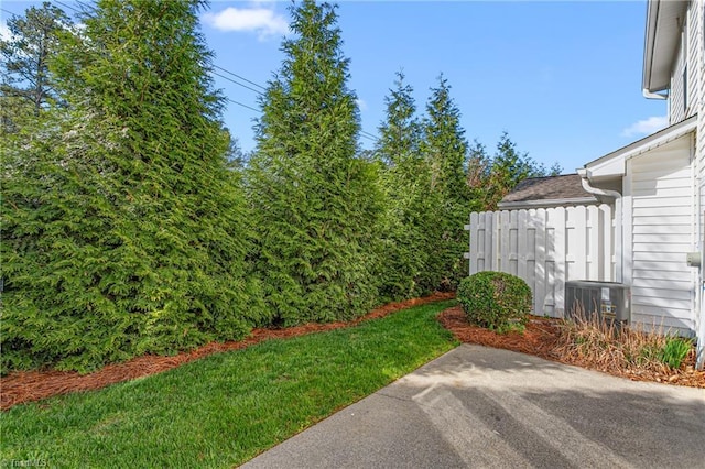 view of yard with a patio, central air condition unit, and fence