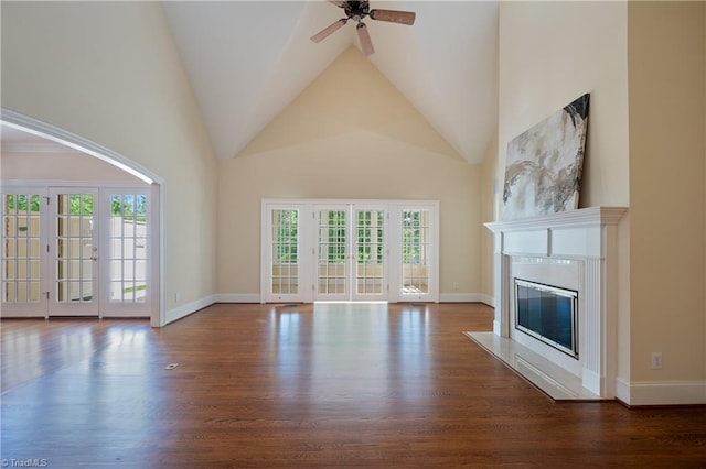 unfurnished living room featuring a ceiling fan, high vaulted ceiling, wood finished floors, and a high end fireplace