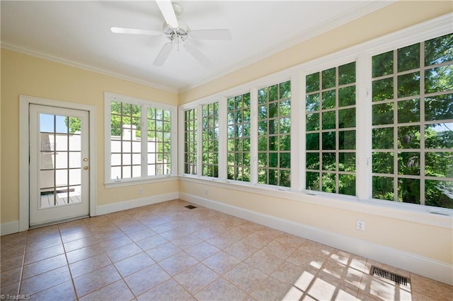 unfurnished sunroom featuring visible vents, ornamental molding, baseboards, and tile patterned flooring