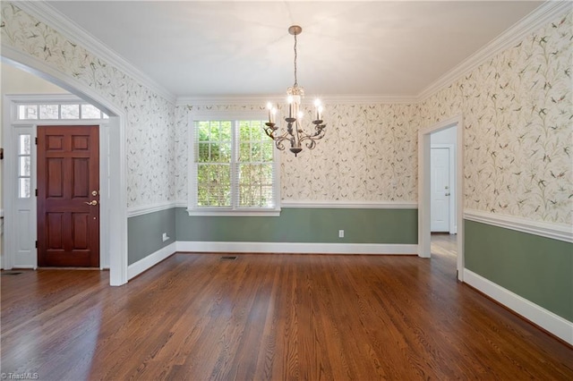 entrance foyer with visible vents, wood finished floors, baseboards, a notable chandelier, and ornamental molding