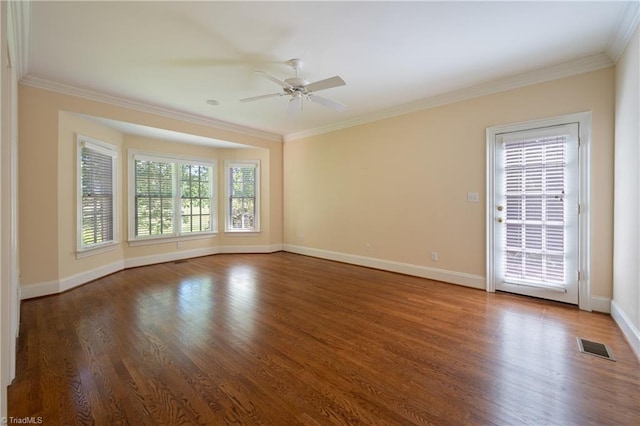 spare room featuring baseboards, ceiling fan, ornamental molding, and wood finished floors