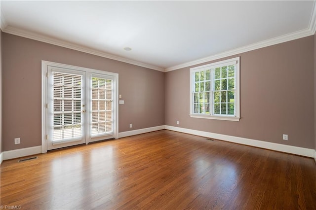 unfurnished room featuring baseboards, ornamental molding, and visible vents