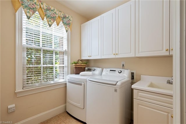 laundry room featuring plenty of natural light, cabinet space, baseboards, and washing machine and clothes dryer