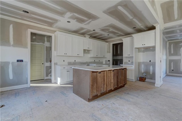 kitchen with a center island, white cabinetry, and ornamental molding