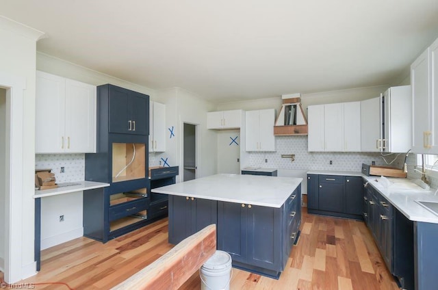 3799 Peony Way, Clemmons, NC 27012 - kitchen featuring a center island, light wood-style flooring, wall chimney range hood, and decorative backsplash