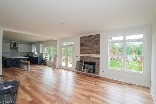 3799 Peony Way, Clemmons, NC 27012 - living room featuring visible vents, light wood-style flooring, a stone fireplace, and baseboards