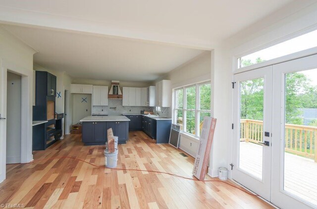 3799 Peony Way, Clemmons, NC 27012 - kitchen featuring a wealth of natural light, a kitchen island, blue cabinets, and wall chimney exhaust hood