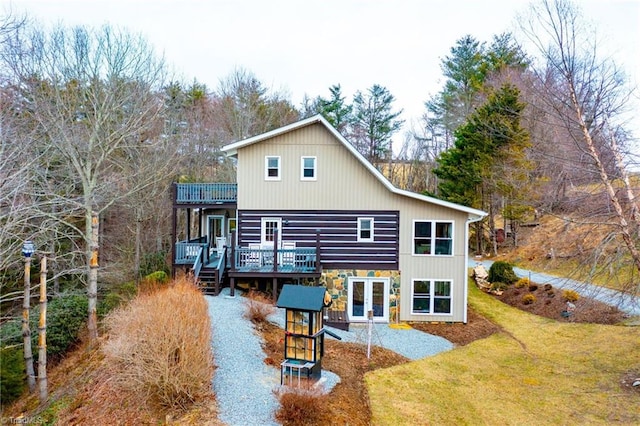 rear view of property featuring a wooden deck, stairs, french doors, and a yard