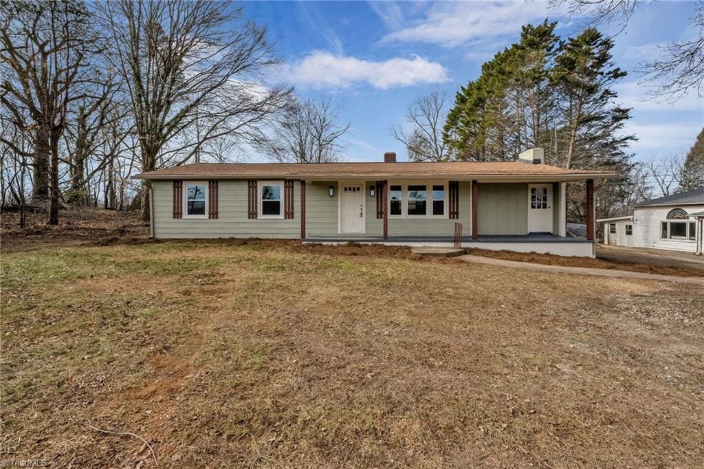 ranch-style home with a front lawn and a porch