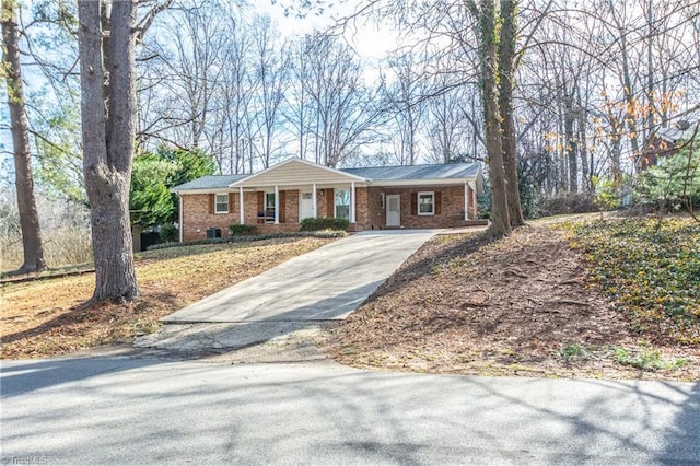 ranch-style house featuring brick siding and driveway