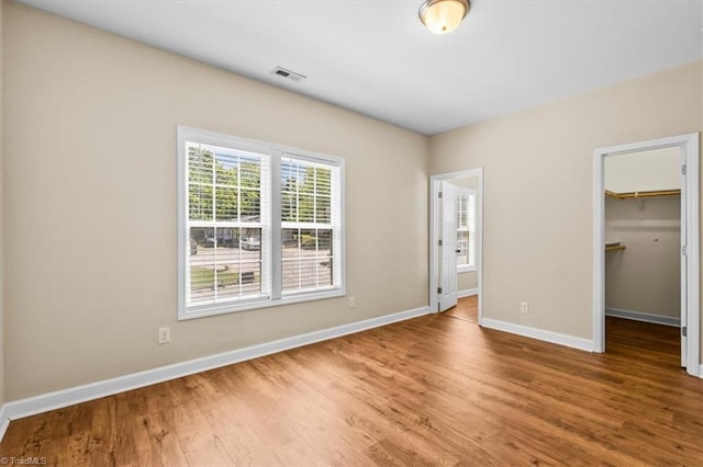 810 Mobile St, High Point, NC 27262 - unfurnished bedroom with wood finished floors, baseboards, a spacious closet, and a closet