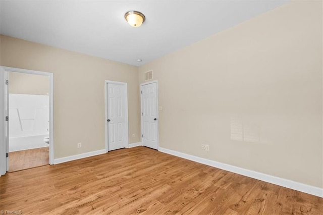 810 Mobile St, High Point, NC 27262 - unfurnished bedroom featuring light wood finished floors, baseboards, and ensuite bathroom