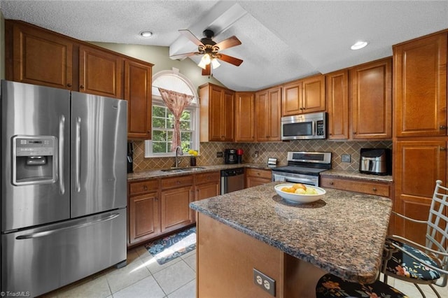 4012 Clarendon Ave, Winston-Salem, NC 27106 - kitchen featuring stainless steel appliances, brown cabinets, ceiling fan, dark stone counters, and lofted ceiling