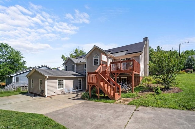4012 Clarendon Ave, Winston-Salem, NC 27106 - back of property with stairway, a chimney, a deck, solar panels, and concrete driveway