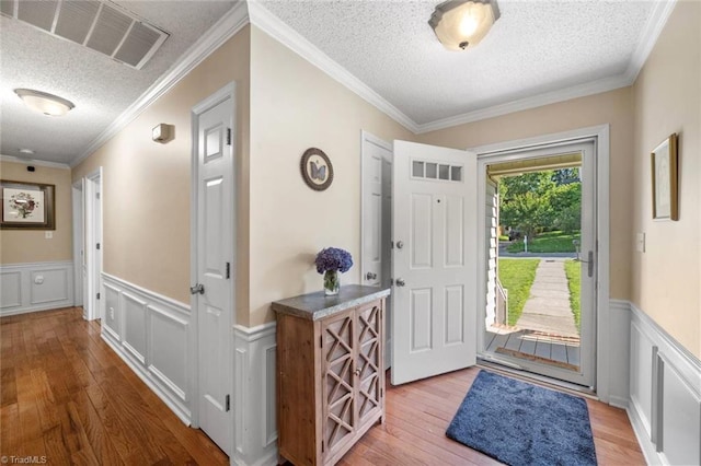 4012 Clarendon Ave, Winston-Salem, NC 27106 - entryway featuring a textured ceiling, wood finished floors, wainscoting, a decorative wall, and ornamental molding