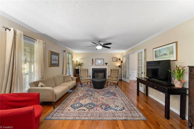 4012 Clarendon Ave, Winston-Salem, NC 27106 - living area with a textured ceiling, wood finished floors, a ceiling fan, a glass covered fireplace, and crown molding