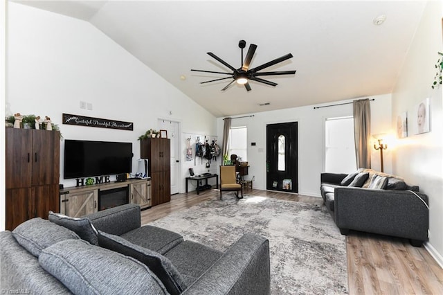 living room featuring light wood-type flooring, visible vents, high vaulted ceiling, a ceiling fan, and baseboards