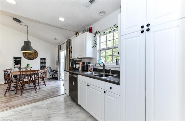 kitchen featuring visible vents, white cabinetry, a sink, stainless steel dishwasher, and dark countertops