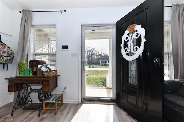 entryway with light wood finished floors, baseboards, and a wealth of natural light