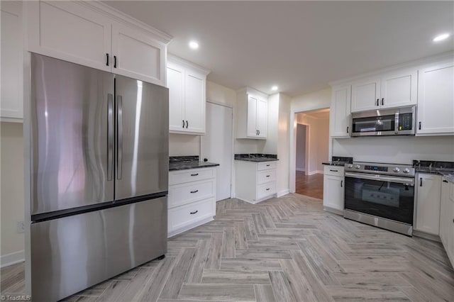 kitchen with white cabinets, stainless steel appliances, and light parquet flooring