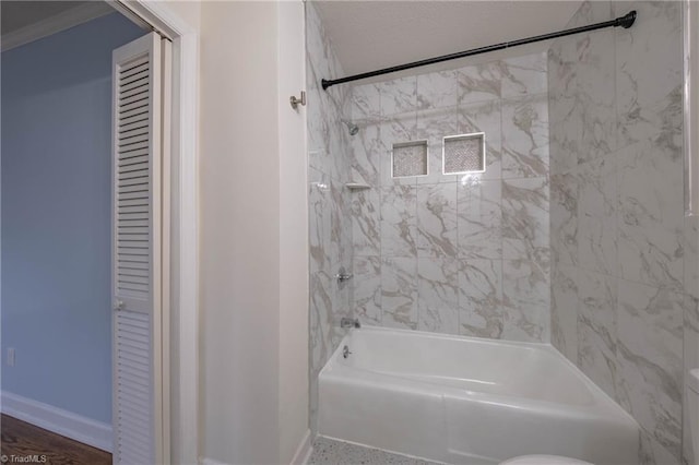 bathroom with hardwood / wood-style flooring and tiled shower / bath combo