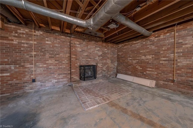 basement with a wood stove and brick wall