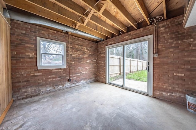 miscellaneous room with concrete flooring and brick wall