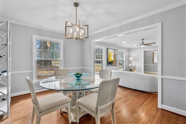 dining room featuring crown molding, a chandelier, wood finished floors, and baseboards