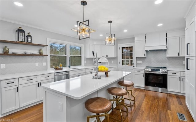 kitchen with white cabinetry, light countertops, appliances with stainless steel finishes, dark wood-style floors, and custom range hood