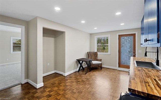 living area featuring baseboards and recessed lighting